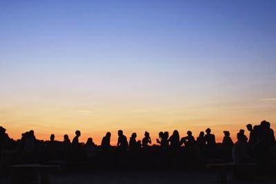 Silhouette people against clear sky during sunset