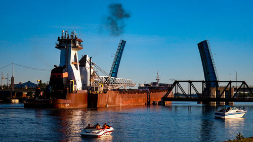 Cranes at commercial dock against sky