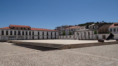 Buildings in city against clear blue sky