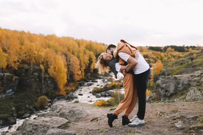 Happy people in love are travel hike in nature in the autumn forest. romantic trip to countryside