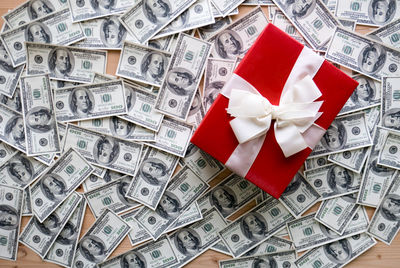 High angle view of gift box with paper currencies on table