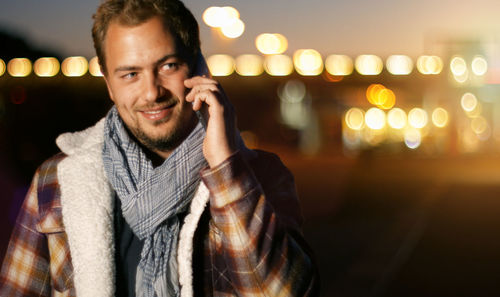 Smiling young man talking on mobile phone