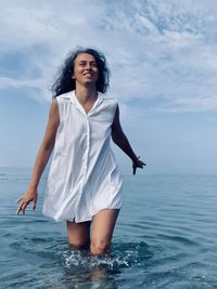 Girl walks on the sea in a white shirt