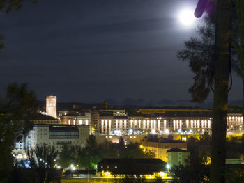 Illuminated city against sky at night