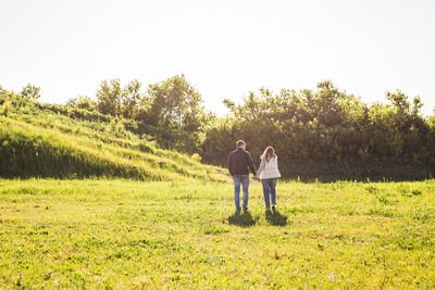 Full length of friends standing on field