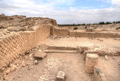 Old ruins on land against sky