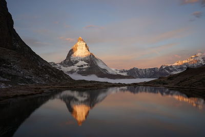 Scenic view of snowcapped mountains against sky during sunset