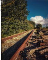 Railroad tracks by trees against sky