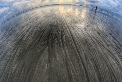 Tilt image of airplane flying over landscape against sky