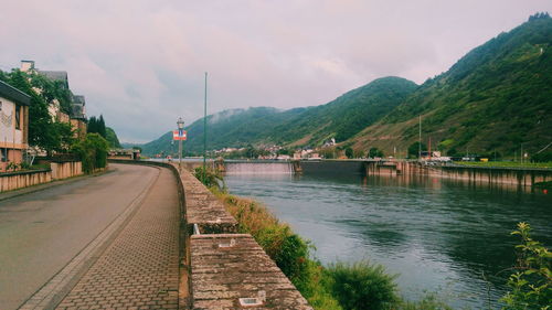 Scenic view of river by mountains in city