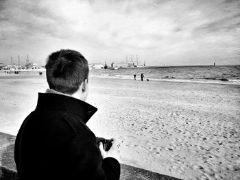 Rear view of woman standing on beach