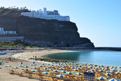 Group of people at beach against clear sky