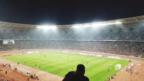 People looking at soccer field at night