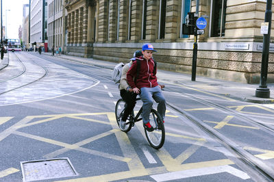 People riding bicycle on road in city