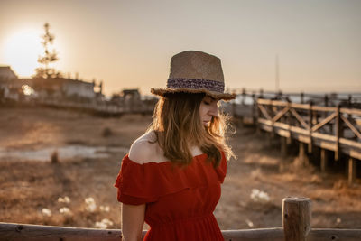 Woman standing against sky during sunset