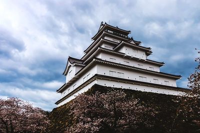 Low angle view of modern building against cloudy sky