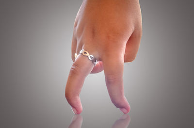 Midsection of woman holding hands against white background