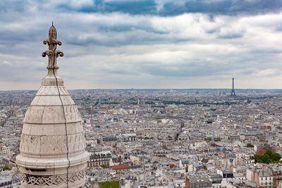 Aerial view of cityscape against cloudy sky