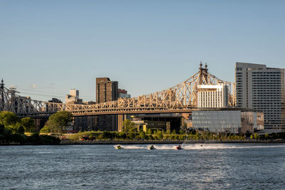 River by buildings against clear sky