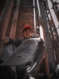 Low angle portrait of man sitting outdoors
