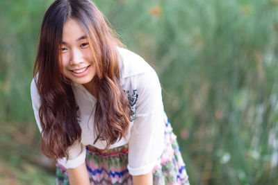 Portrait of young woman standing against plants