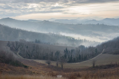 Scenic view of landscape against sky during foggy weather