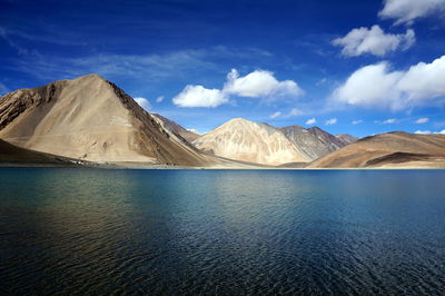 Scenic view of river and mountains against sky