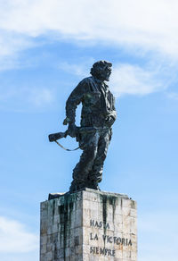 Low angle view of old statue against sky