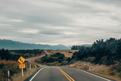 Road leading towards mountain against sky