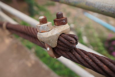 Close-up of rusty padlock on ropes