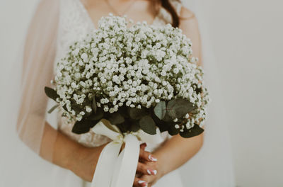 Portrait of a young unrecognizable caucasian bride with a bouquet of boutonnieres.