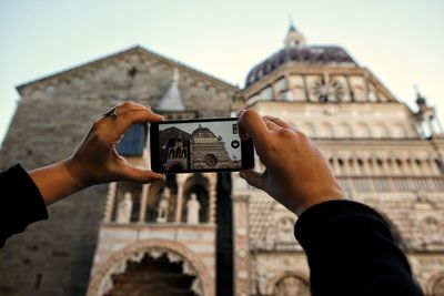 Midsection of man photographing with mobile phone