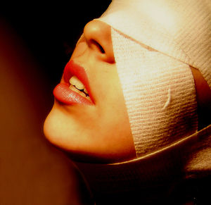 Close-up of young woman over black background