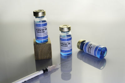 High angle view of bottles on shelf against white background