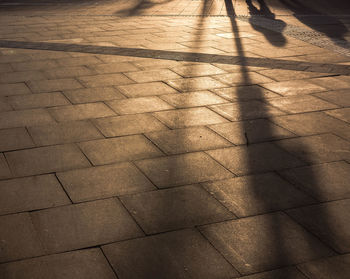 High angle view of shadow on footpath during sunset