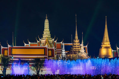 Group of people in front of illuminated building at night