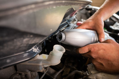 Midsection of man working on motorcycle