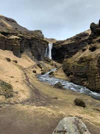 Scenic view of waterfall against sky