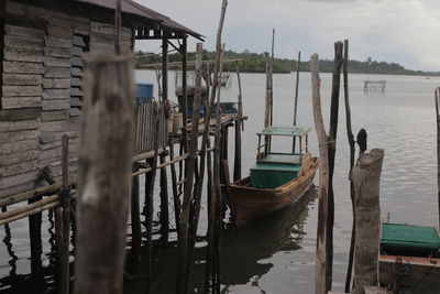 Wooden posts in lake against sky