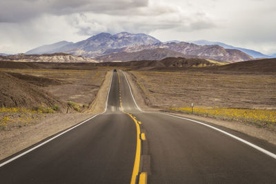 Empty road along countryside landscape