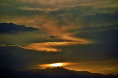 Scenic view of silhouette mountains against sky at sunset