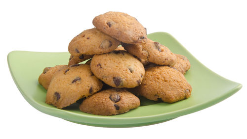 Close-up of cookies in plate against white background