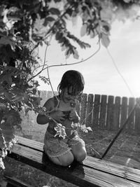 Portrait of young woman sitting on bench