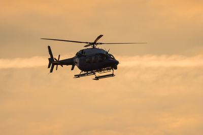 Low angle view of silhouette airplane against sky during sunset