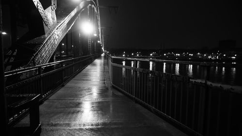 Illuminated footbridge over canal at night