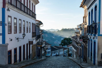 Street amidst buildings in town against sky