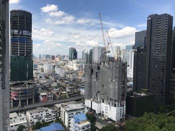 Buildings in city against cloudy sky