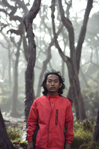 Portrait of young woman standing in forest