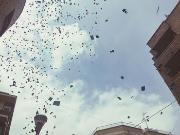 Low angle view of birds flying against sky