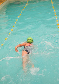 Little girl swimming in professional pool